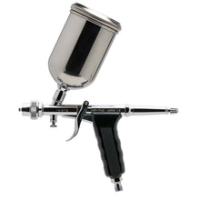Iwata HP-TH2 gravity feed dual action trigger airbrush with pistol grip and large paint cup for versatile spray patterns.